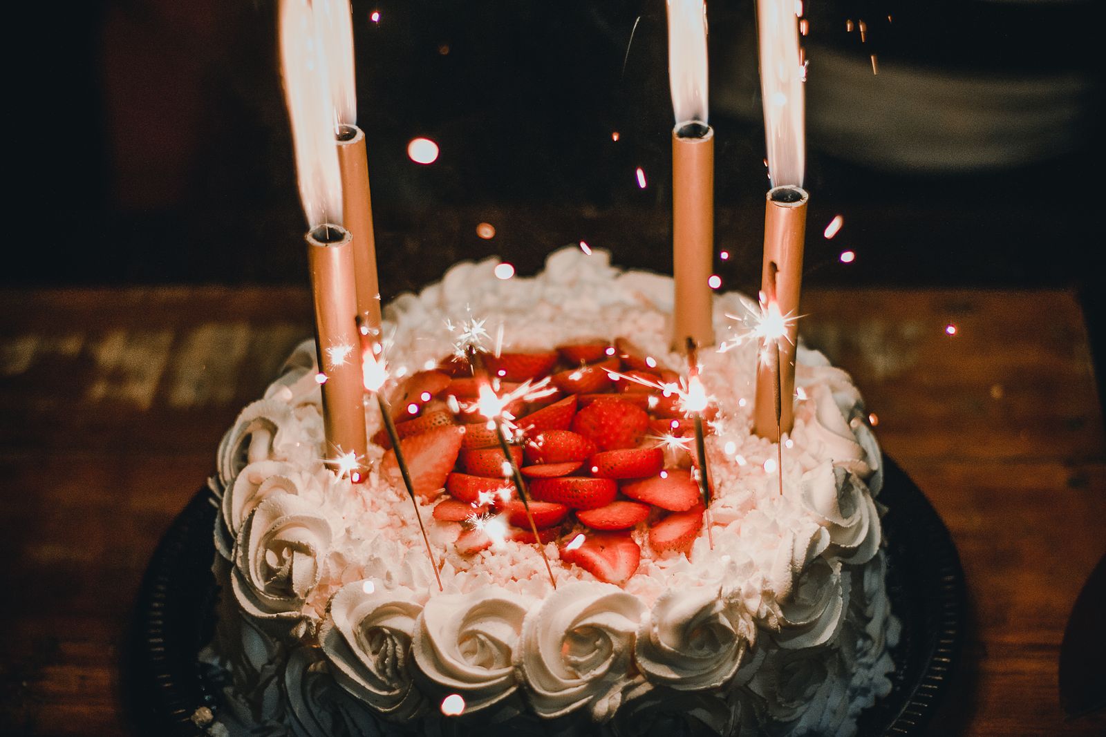 Detalhe de um bolo de aniversário com velas acesas